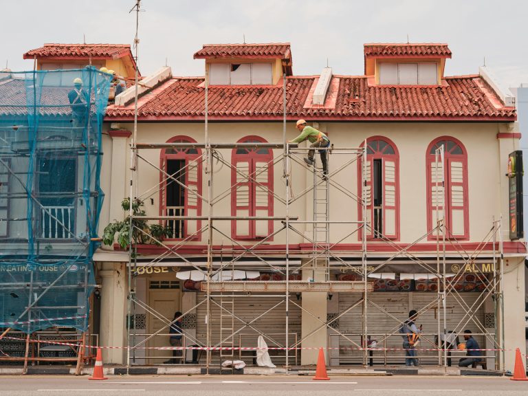 Workers carrying out renovation work from scaffolding on a building facade